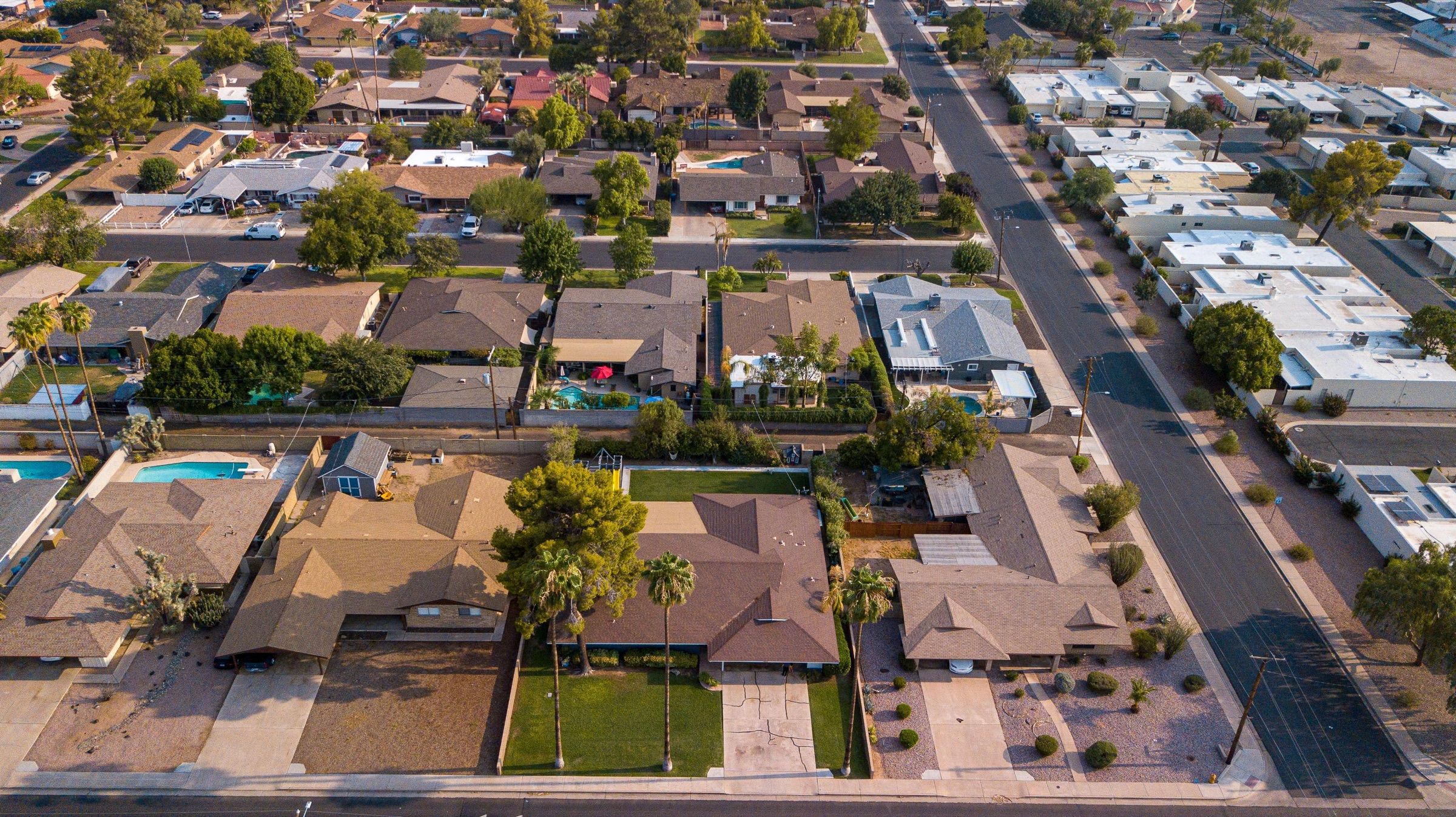 An aerial view of a suburban neighbourhood with rows of detached houses and gardens