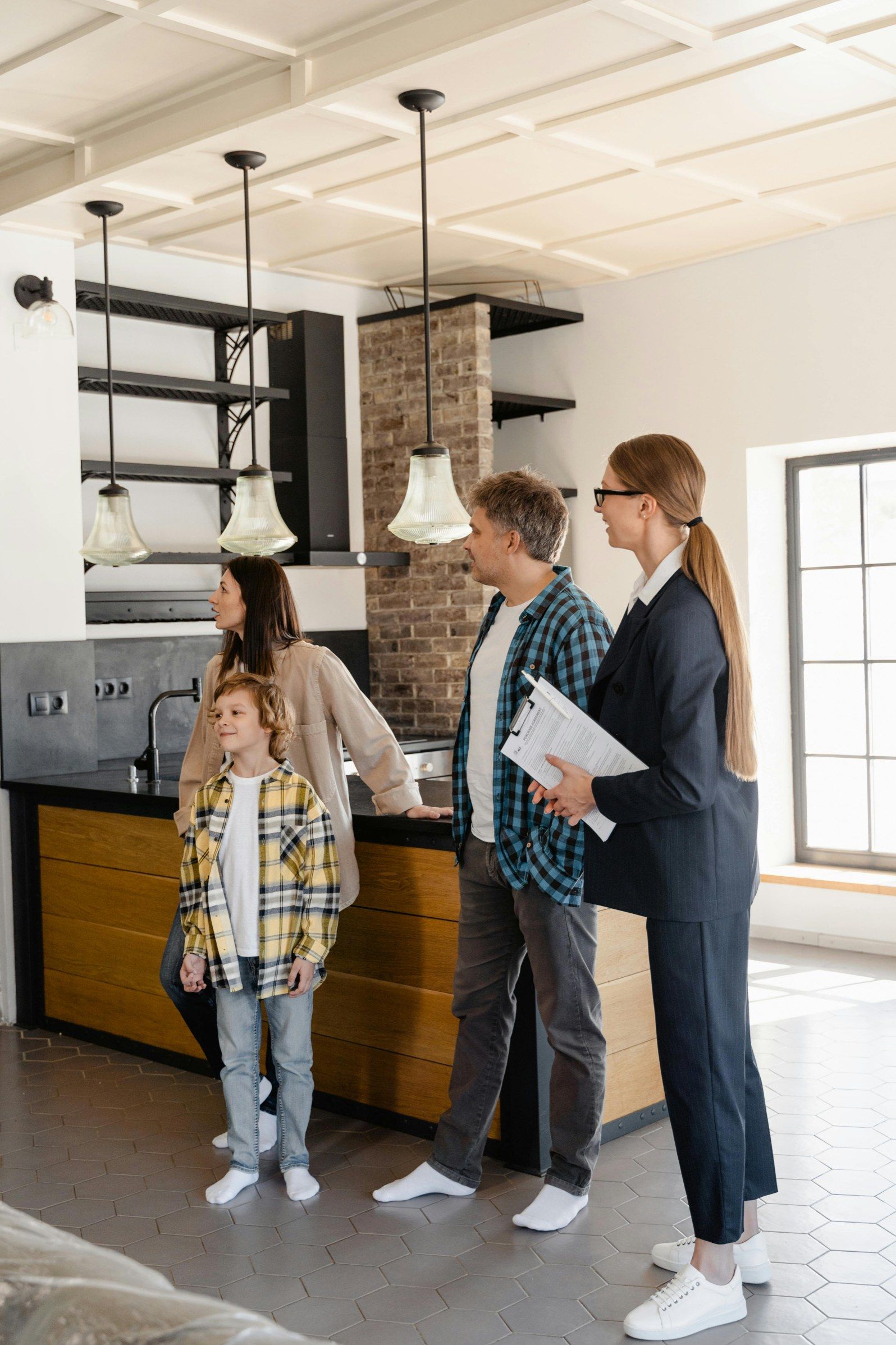 An agent showing a family with a young child around a kitchen