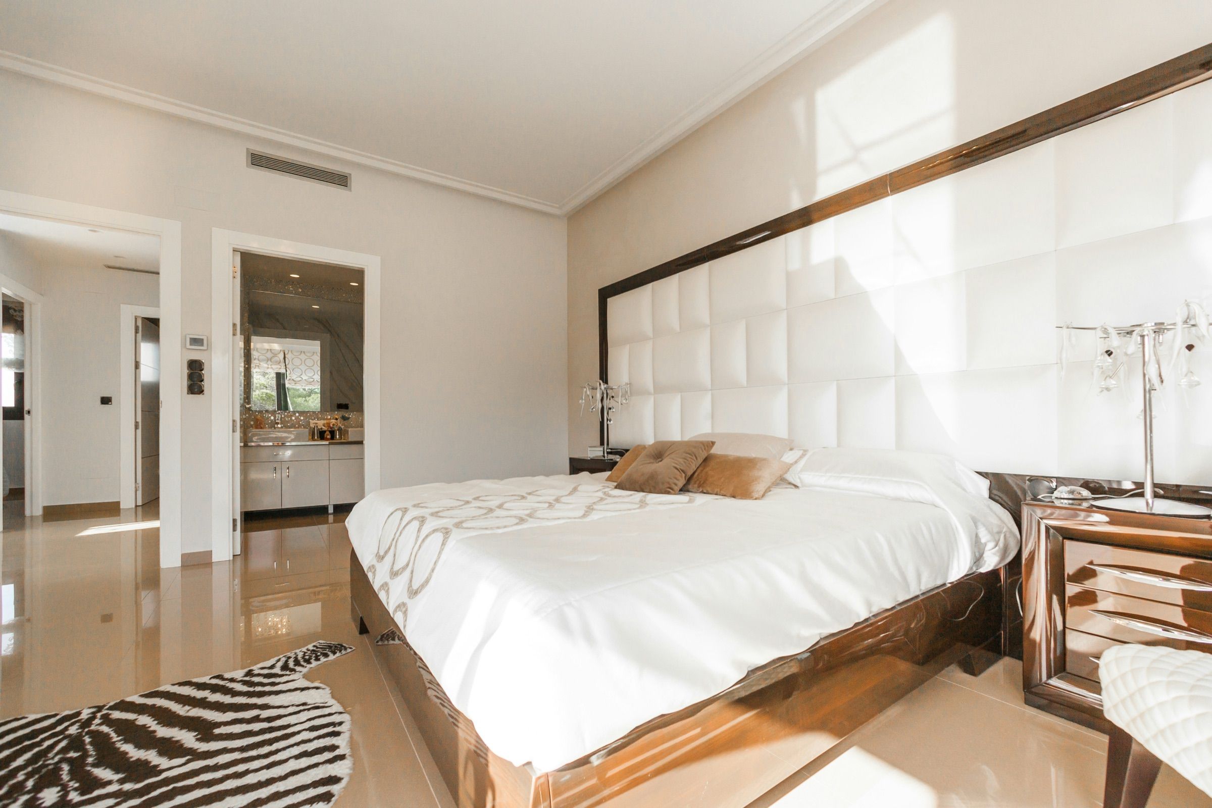 Bedroom with a padded headboard and soft natural light