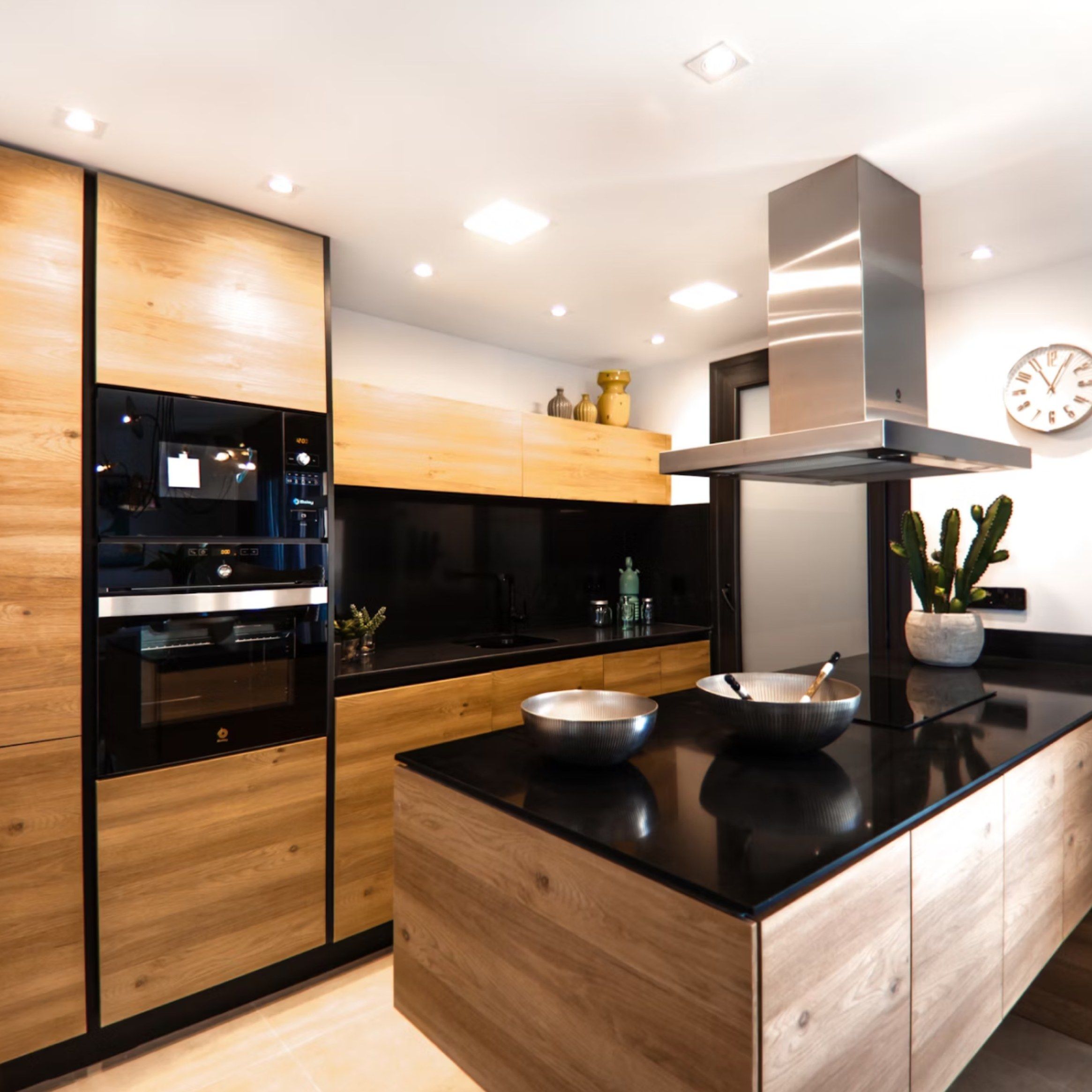 The same kitchen from further back, showing the island, tall units and extractor hood